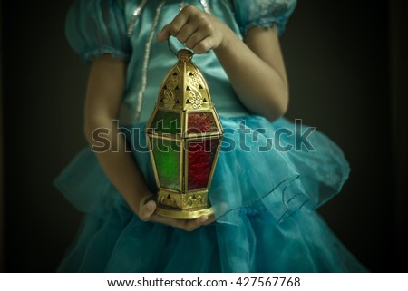A Close up of a girl holding beautiful decorative Ramadan lantern in hand. Celebration in Holy month of  Ramadan.