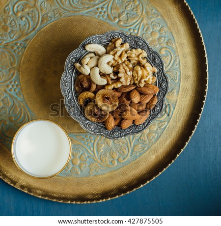Bowl of mixed nutritious nuts and glass of fresh milk. A healthy food for breaking Ramadan Fast.
