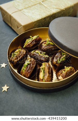 Gourmet date fruits stuffed with pistachio nuts presented in an exotic gift box. Eid festival sweet and condiments.