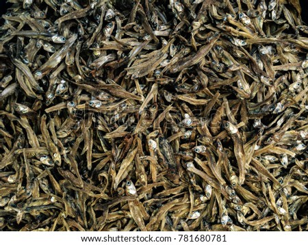 Heap of tiny dried sardines selling in fish market. A background of salted fish. Dry fish is a popular seafood ingredient in an Asian cuisine.