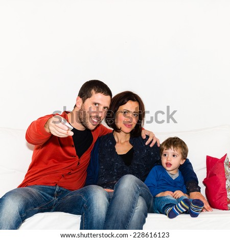 Mother and father watching tv with son on the couch
