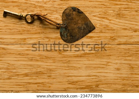 Magic key and heart on wooden background