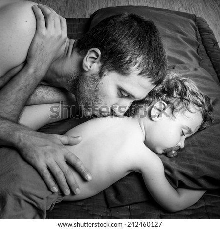 Caucasian father and son sleeping together - Black and white