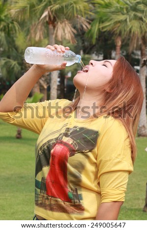 woman drink water in park and water flowed from her mouth