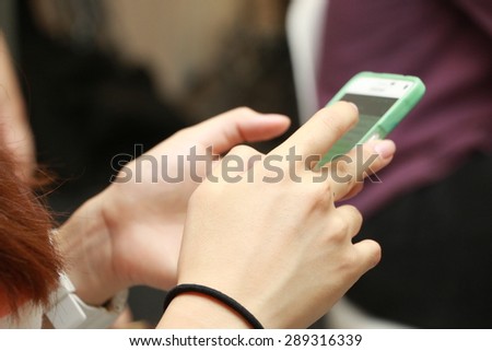 Close up hands of women using cell phone, tablet