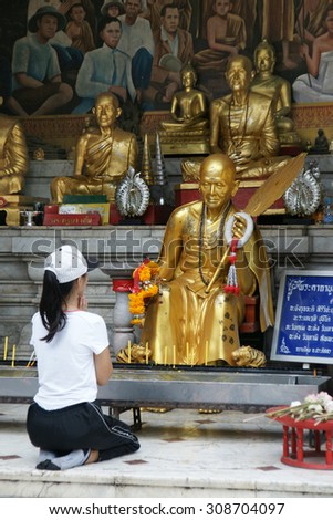 CHIANGMAI, THAILAND - 5 July 2015 : Unidentified female tourism pray to monk sculpture at Doi Suthep Temple, Chiangmai, north of Thailand.
