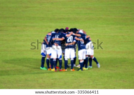 Blur image of rear view of soccer players which discussing strategy before game.