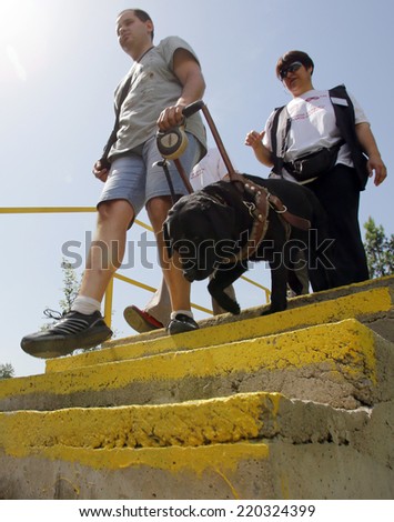 Blind person with his guide dog/Sofia, Bulgaria - June 25, 2014: A blind man is led by his guide dog trough stairways as part of dog\'s training.