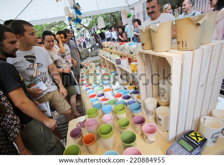 Sofia, Bulgaria - August 17, 2014: Customers are looking at colourful tea cups sold by a producer at the urban art festival in the center of Bulgaria\'s capital.