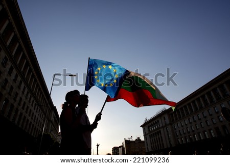 Sofia, Bulgaria - August 6, 2013: Siluettes of people holding Bulgarian and EU flags at an anti-government protest at Bulgaria\'s capital Sofia.