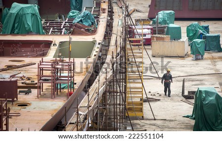 Shenzhen, China - August 6, 2014: Worker at a container cargo harbor is going for his lunch hour.