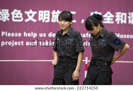 Beijing, China - August 4, 2014: Two female law enforcement officers are monitoring the entrance of The Forbidden City in Beijing.