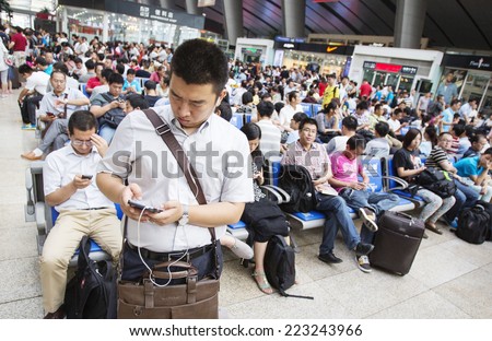 Beijing, China - August 6, 2014: People are waiting for a train at an overcrowded railway station in Beijing.