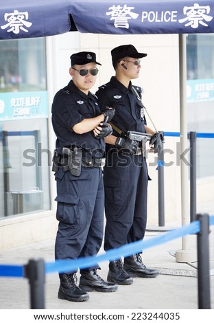 Beijing, China - August 6, 2014: Two Chinese police officers are standing on their post in front of a railway station in Beijing.