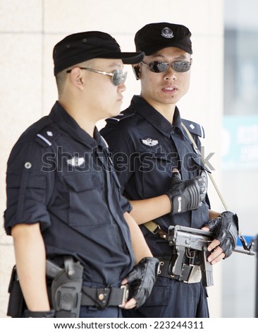 Beijing, China - August 6, 2014: Two Chinese police officers are standing on their post in front of a railway station in Beijing.