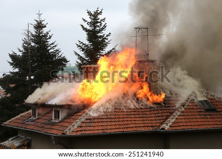 A house roof on fire and smoke.