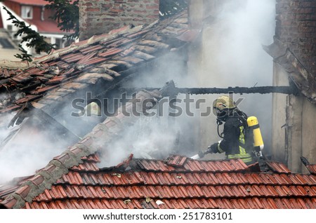 Sofia, Bulgaria - November 24, 2012: Firefighters are extinguishing fire on a burning house roof.