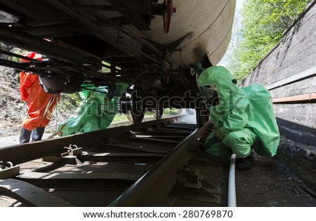 Team working with toxic acids and chemicals is securing train tanks crashed near Sofia, Bulgaria. Teams from Fire department are participating in a training with spilled toxic and flammable materials.