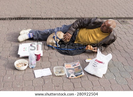 Budapest, Hungary - April 30, 2015: An old man is begging on the ground of a main street in Budapest, Hungary.
