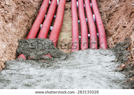 Concreting red corrugated pipes for electrical installation.