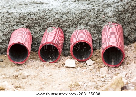 Concreting red corrugated pipes for electrical installation.