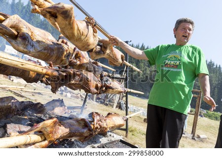 Rojen, Bulgaria - July 19, 2015: A cooker is preparing a traditional Bulgarian roasting lamb barbecue. It is roasted meat over an open fire, cooked in a special way.
