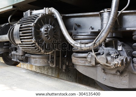 Old authentic green passenger trains in a depot for renovation before being used for tourist trips across Europe. Details of the train\'s transmission.