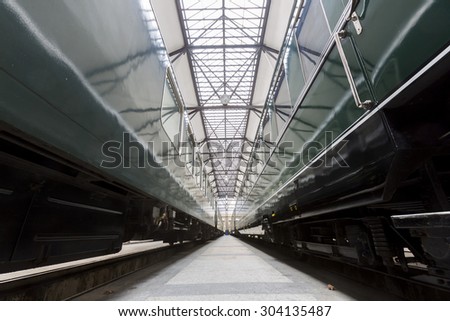 Old authentic green passenger trains in a depot for renovation before being used for tourist trips across Europe. Details of the train\'s transmission.