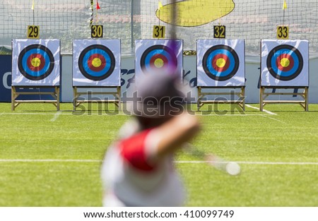 A person is shooting with recurve bow on a target during an archery competition. Focus on the targets.