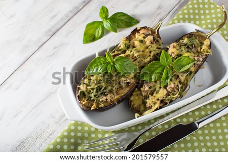 Baked eggplant with basil and cheese in light background
