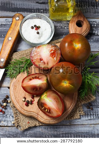 Black tomato kumato in wooden board. Selective focus