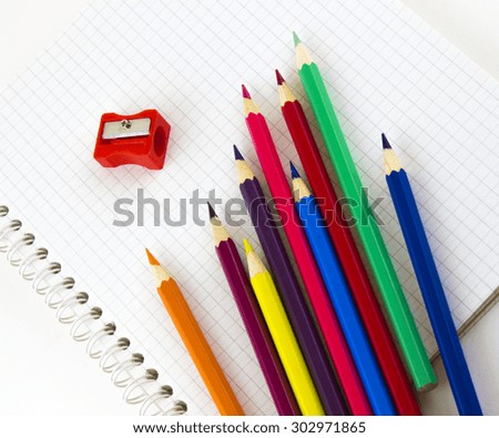 School supplies on the clean white copybook.