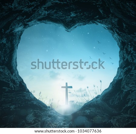 Crucifixion of Good Friday concept: Heart shape of empty tomb stone with silhouette cross over meadow night background