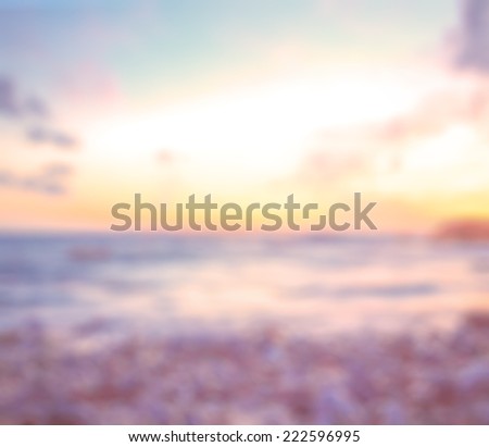 Blurred sunset background. Sandy beach backdrop with turquoise water and bright sun light. Summer holidays concept.
