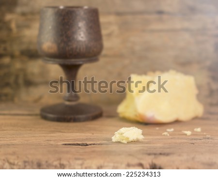 Pieces of bread to be divided in eucharist for christian, the believers in Jesus. Focus on Pieces of bread Blurred glass of wine and loaf of bread.