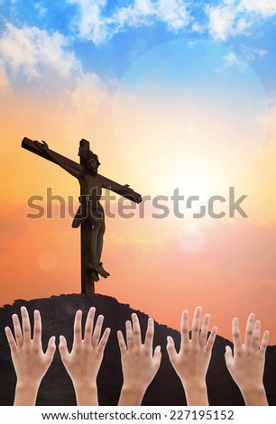 Human raising hands over blurred crown of thorns and the cross on a sunset.