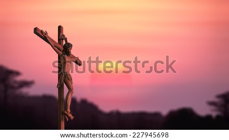 Silhouette Jesus and the cross over blurred sunset background