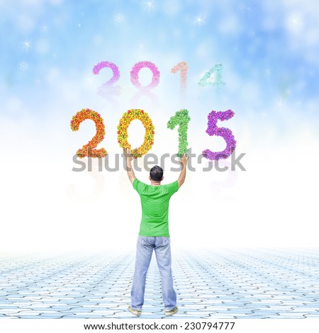 2014-2015 change represents the new year 2015. A man raising hands on stone paving over fruitful text for 2014, 2015 and winter background.