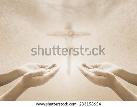 Sepia tone, hands of man praying over blurred crown of thorns and Jesus and the cross on a sunset.