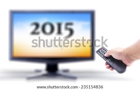 2014-2015 change represents the new year 2015. Human hand holding remote and out of focus TV LCD monitor isolated on white.
