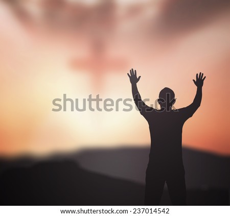 Silhouette people raising hands over blurred crown of thorns and the cross on nature background.