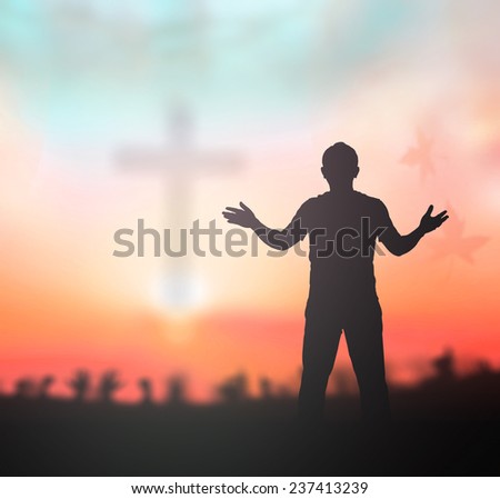 Silhouette people raising hands over blurred crown of thorns and the cross on nature background.