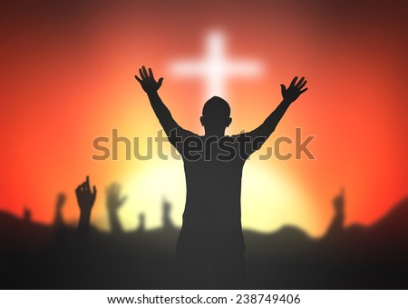 Silhouette people raising hands over blurred the white cross on sunset background.