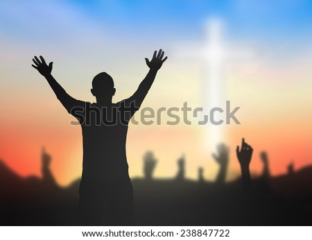 People raising hands over blurred the white cross.