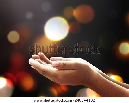 Children open empty hands with palms up over blurred beautiful bokeh of sunset background. Vintage style.