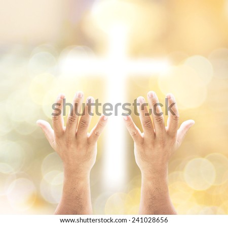 Human open empty hands with palms up, over blurred the cross and bokeh on night background.