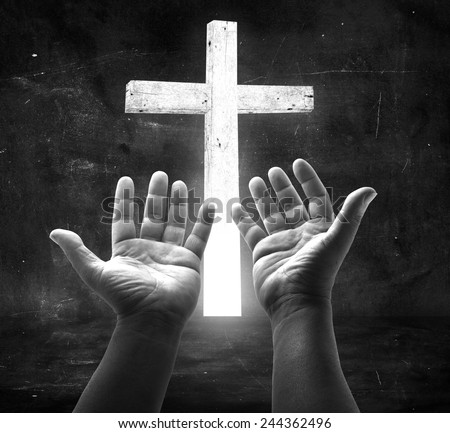 Human open empty hands with palms up, over the white cross in the dark room background. Forgiveness Mercy Humble Evangelical Hallelujah Thankful Redeemer Amen Pray Hope Merry Christmas Card concept.