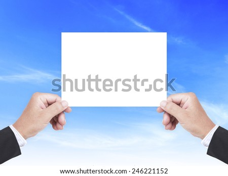 Business man hands holding a white A5 international paper over blue sky background.