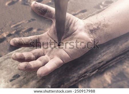 Bleeding hand with nail in it on wood.