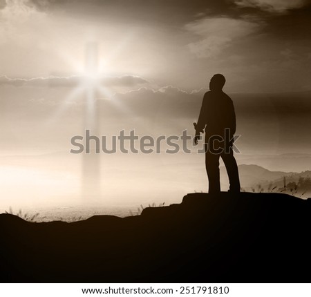 Silhouette human standing over blurred the cross on nature background.